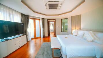 A modern hotel room with a large bed, a flat-screen TV, a desk, and a view of the hallway.