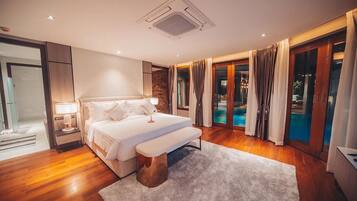 A modern bedroom with a large bed, a bedside table, a bench, and a view of a swimming pool through glass doors.