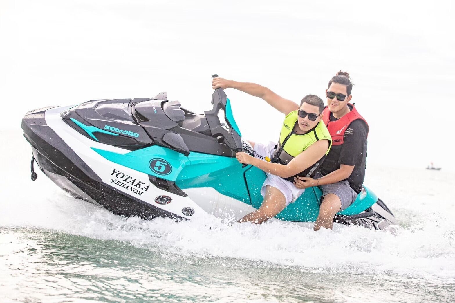 Dos personas en un jet ski, con un logotipo y nombre del modelo visibles.