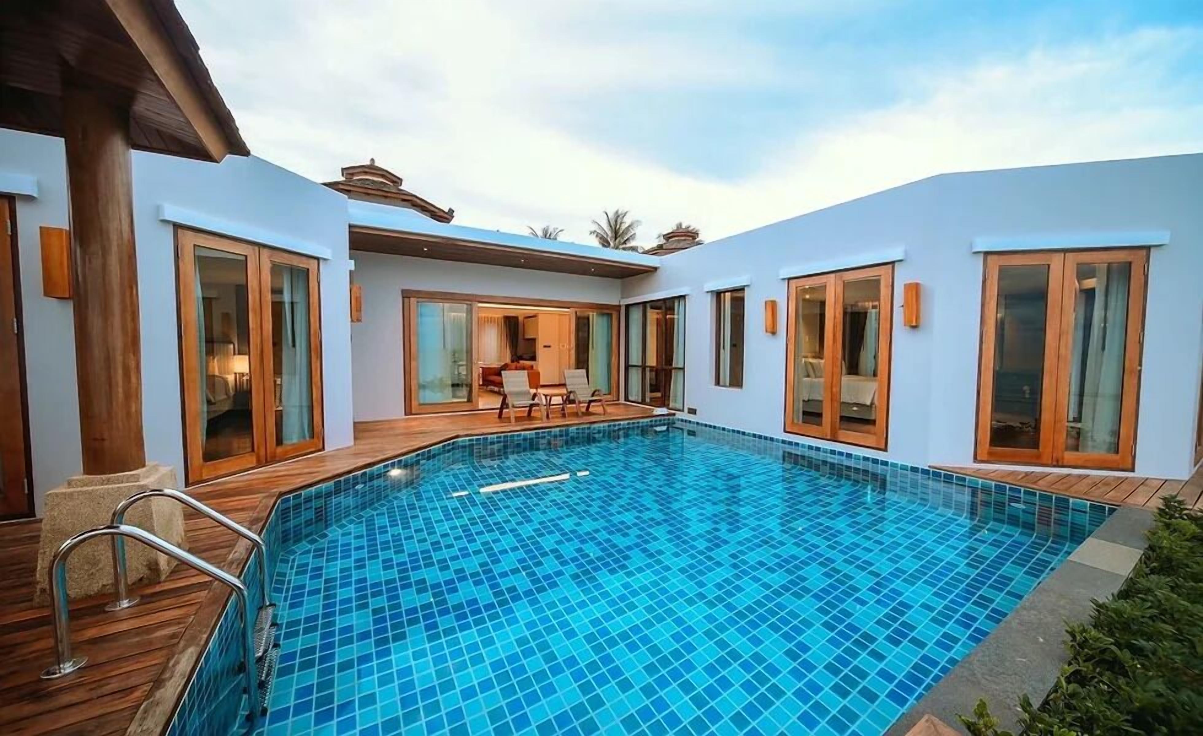 A modern pool area with glass doors and a wooden deck.