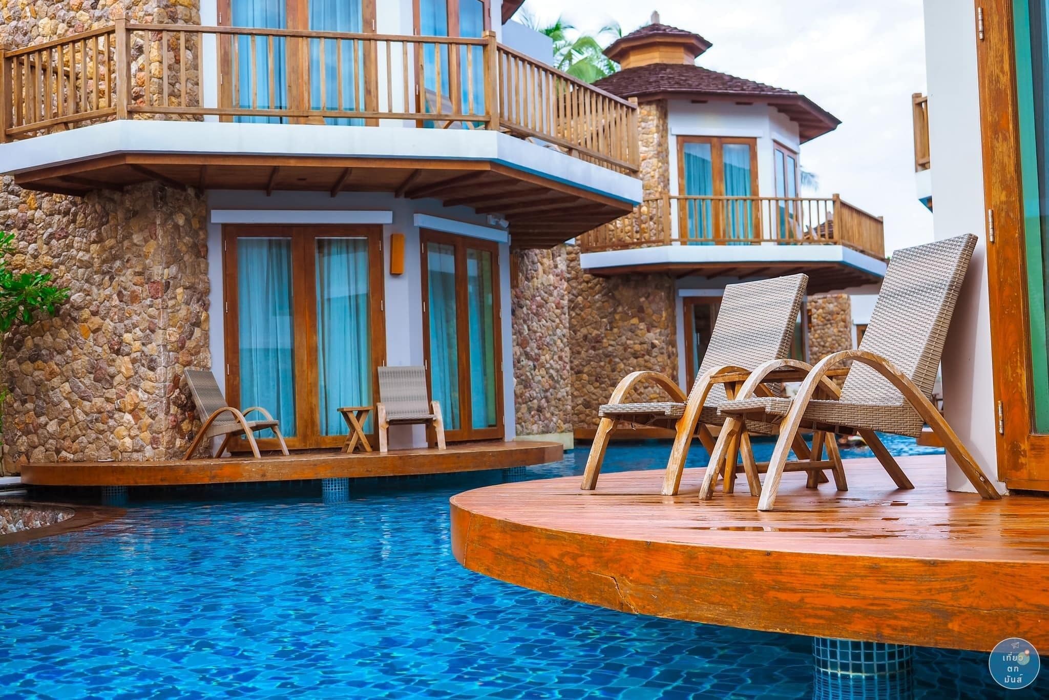 Uma área de piscina com espreguiçadeiras e um muro de pedra.