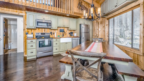 Cucina spaziosa con mobili in legno, una grande isola e vista sull'esterno attraverso una finestra.