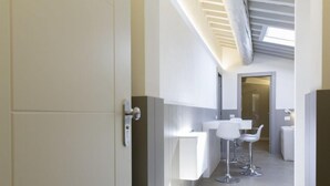 Une salle de bain moderne avec un lavabo blanc, deux tabourets de bar et un miroir.