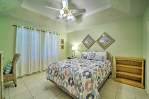A bedroom with a bed, a chair, a nightstand, a lamp, and two framed pictures on the wall. - Deck & Pool Access: Long Island Village Escape! (Port Isabel)