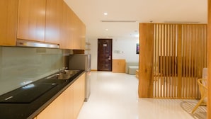 Une cuisine moderne avec des meubles en bois, un plan de travail noir et des appareils électroménagers en acier inoxydable.