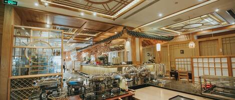 A restaurant with a traditional Japanese interior, featuring wooden beams, tatami mats, and a central counter with food display.