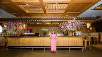 A reception area with a wooden counter, traditional decor, and a person standing behind it.