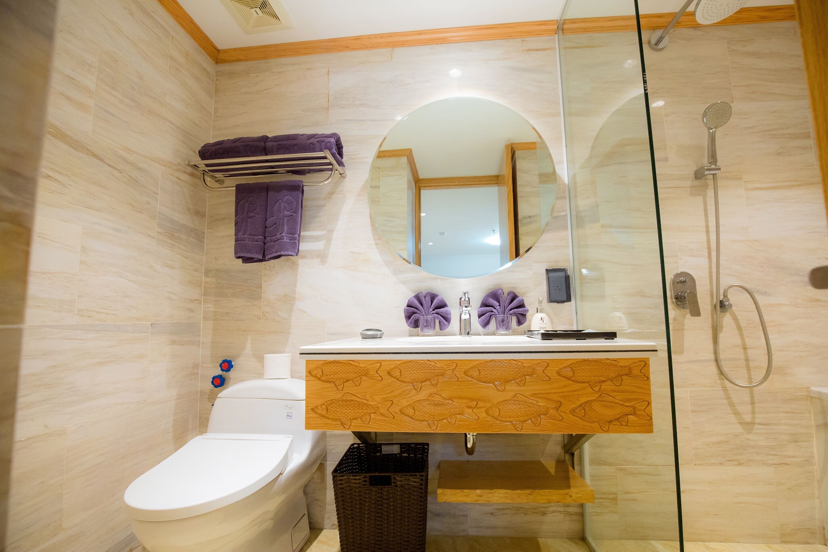 Un baño con inodoro, lavamanos con espejo y ducha.