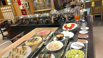 Ein reichhaltiges Buffet mit verschiedenen Speisen, darunter Sandwiches, Aufschnitt und Gemüse.