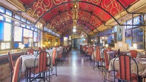 A spacious restaurant with a high, ornate ceiling and rows of tables and chairs. - Hotel Adarsha Palace (Belagavi)