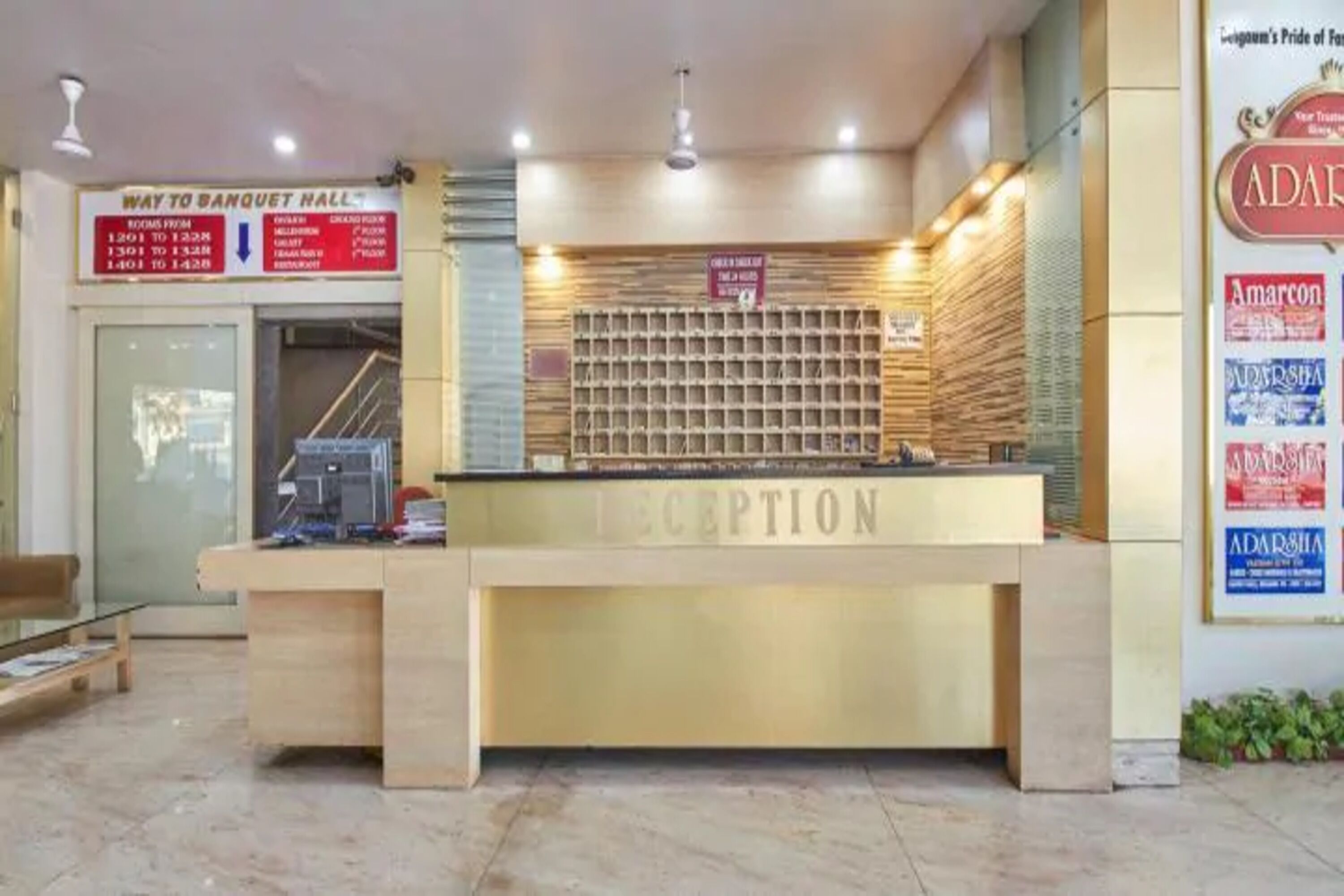 Una mesa de recepción con un letrero que indica el camino al salón de banquetes y otras instalaciones.