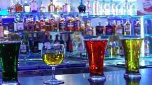 A bar with various bottles and glasses of different colors. - Hotel Adarsha Palace (Belagavi)