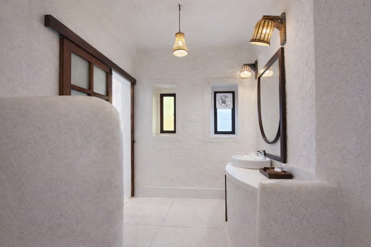 Un baño moderno con un espejo grande, un lavabo y una lámpara.