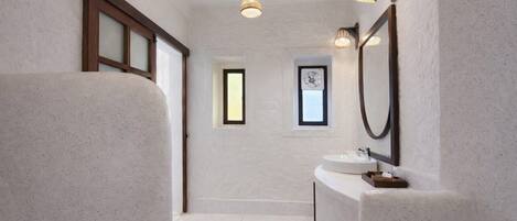 Un baño moderno con un espejo grande, un lavabo y una lámpara.