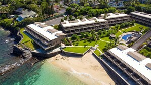 An aerial view of a resort with multiple buildings, a beach, and clear turquoise waters. - Kahana Sunset E10:  Summer and Fall Savings!  Free Activities! (Kahana)