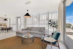 Relax in this stylish living room with a grey sofa, round coffee table, and blue armchair.