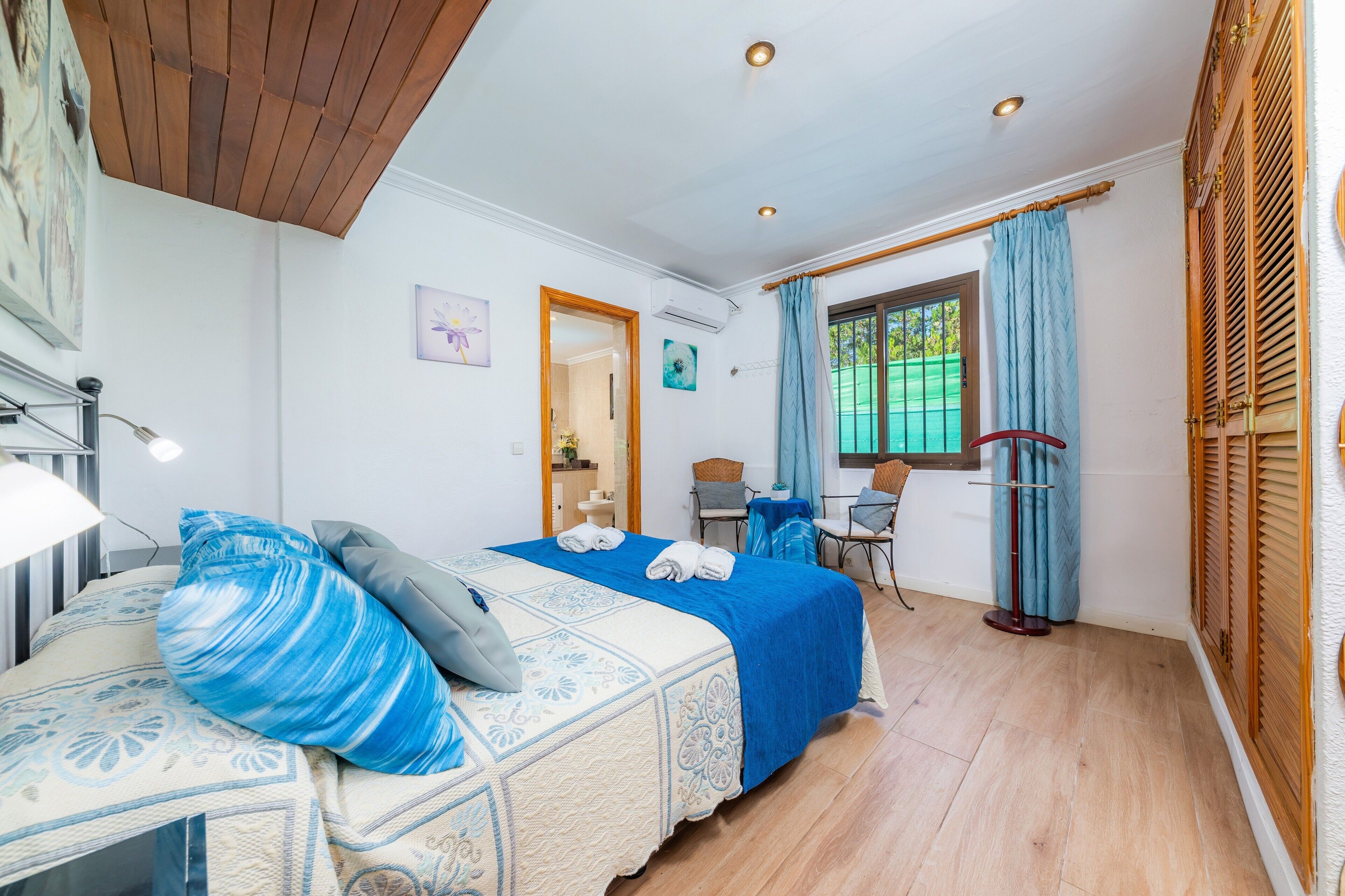 Un dormitorio con cama, escritorio y silla.