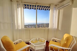 A balcony with two wicker chairs and a small table with cups, overlooking a cityscape. - Cozy townhouse with ocean views  (Costa Adeje)