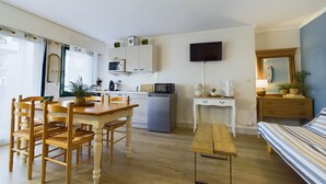 Een knus woongedeelte met een eethoek, kitchenette en een bed.