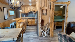 A rustic cabin interior with wooden furniture, a dining area, a kitchen, and a bed. - 8 Min to State Parks|Sauna|Fire Pit| (Beaver Bay)