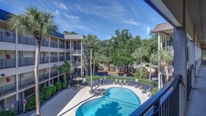 A hotel with a pool area, multiple balconies, and palm trees. - BEACHFRONT KING BED VILLA, PRIVATE BALCONY, SELF CHECKIN, FLEXIBLE CANCELLATION (Hilton Head Island)