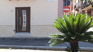 Un edificio con una insegna che riporta “PIAZZA FRANCESCO CIPOLLA” e una porta con il numero “6”.