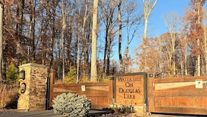 A gated entrance with a sign reading 'Waterside on Douglas Lake,' a stone wall, and a small bush. - Like New Lake & Mountain Views from every room in the house! (Dandridge)