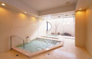 Relax in a serene spa area featuring two hot tubs with clear glass enclosures.