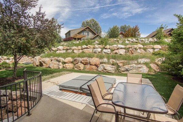 Relax in the serene garden setting, surrounded by lush greenery and a hillside view.