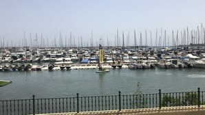 A marina filled with various boats and yachts, a clear sky, and a fence in the foreground. - fan de golf ou de quiétude cet endroit est fait pour vous  (Orihuela Costa)