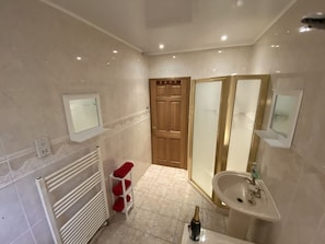 A bathroom with a white sink, a mirror, a shower, and a door. - Country Cottage Sleeps 6 w/ Hot Tub & Dog-friendly (Thornhill)