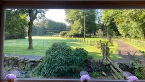 A view of a well-maintained garden with a stone wall, a wooden fence, and a pathway leading to a gate. - Country Cottage Sleeps 6 w/ Hot Tub & Dog-friendly (Thornhill)