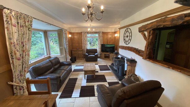 A cozy living room with a fireplace, leather sofas, and a television. - Country Cottage Sleeps 6 w/ Hot Tub & Dog-friendly (Thornhill)