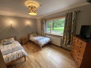 A bedroom with two beds, a dresser, a TV, and a window with curtains. - Country Cottage Sleeps 6 w/ Hot Tub & Dog-friendly (Thornhill)