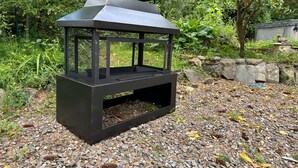 A black metal lantern-style outdoor light fixture on a gravel surface surrounded by greenery. - Country Cottage Sleeps 6 w/ Hot Tub & Dog-friendly (Thornhill)