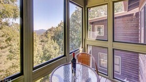A room with large windows offering a view of trees and mountains. - Carson's Run on Cedar Mountain--Cozy retreat with spectacular mountain views.  (Dahlonega)