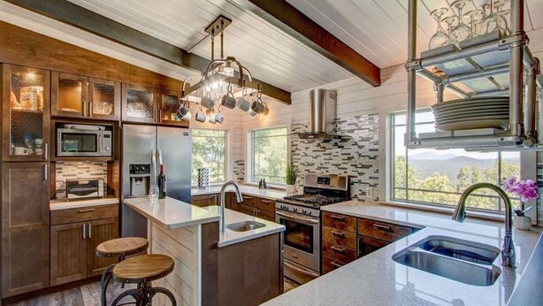 A modern kitchen with a large island, stainless steel appliances, and a view of the outdoors. - Carson's Run on Cedar Mountain--Cozy retreat with spectacular mountain views.  (Dahlonega)