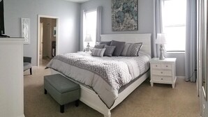 A bedroom with a large bed, a nightstand, a bench, and a dresser. - 8BR ChampionsGate | Cinema, Arcade & Private Pool (Davenport)