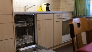 Ett kök med diskmaskin, brödrost och spis.