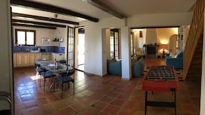 A spacious living area with a glass dining table, a foosball table, and a cozy seating area with a fireplace. - Private Family Villa in Verdon, Var, Provence - Pool and 2,000 m² Garden - Sleeps 10 (regusse)