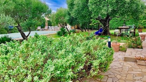 A garden with various trees and shrubs, a stone pathway, and outdoor furniture. - Private Family Villa in Verdon, Var, Provence - Pool and 2,000 m² Garden - Sleeps 10 (regusse)