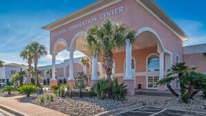 A convention center with a red brick facade, white columns, and palm trees in the foreground. - 2nd floor 2 BR, 2 bath, Sunset Beach 5 mins from Ocean @ Sea Trail Golf Resort  (Sunset Beach)