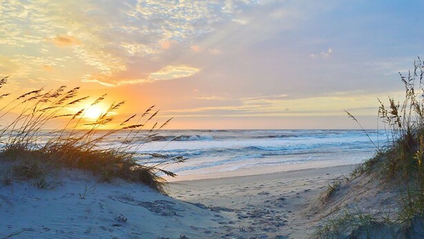A beach scene with a sunset, sandy dunes, and grass in the foreground. - 2nd floor 2 BR, 2 bath, Sunset Beach 5 mins from Ocean @ Sea Trail Golf Resort  (Sunset Beach)