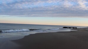 A beach with a wooden pier extending into the water, a clear sky, and gentle waves. - Spacious 4 Bed, 4,5 bath. Pet friendly. Come enjoy Rehoboth! (Rehoboth Beach)