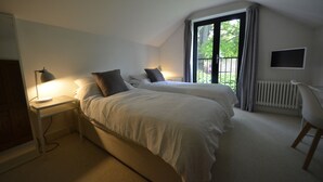 A bedroom with two beds, a desk with a lamp, a chair, and a window with curtains. - Spacious Open Plan House in Central Windsor. Dog Friendly + Off Street Parking! (Windsor)