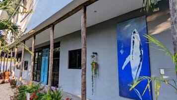 Stunning building with a unique abstract whale artwork and lush greenery.