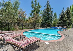 A swimming pool with lounge chairs and a fenced area. - Short Walk to the Resort | Fireside + Shuttle (Steamboat Springs)