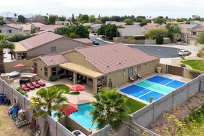 A residential area with a swimming pool, patio furniture, and a covered outdoor seating area.