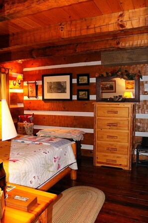 A cozy room with a wooden bed, a wooden dresser, and a lamp. - Hand hewn log cabin with beautiful views of the Blue Ridge Mountains  (Roseland)