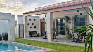 A modern house with a swimming pool, a patio with outdoor furniture, and a well-maintained lawn. - Hotel Plaza Matamoros (Matamoros)